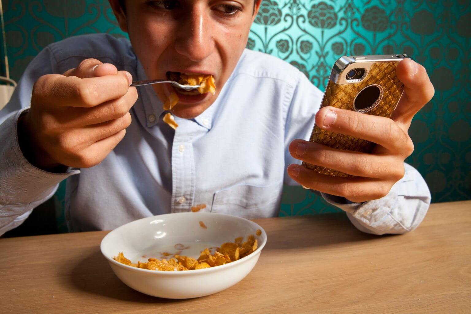 Вредно сидеть в телефоне. Кушает с телефоном. Человек кушает. Человек с мобильником за едой. Человек кушает с телефоном.