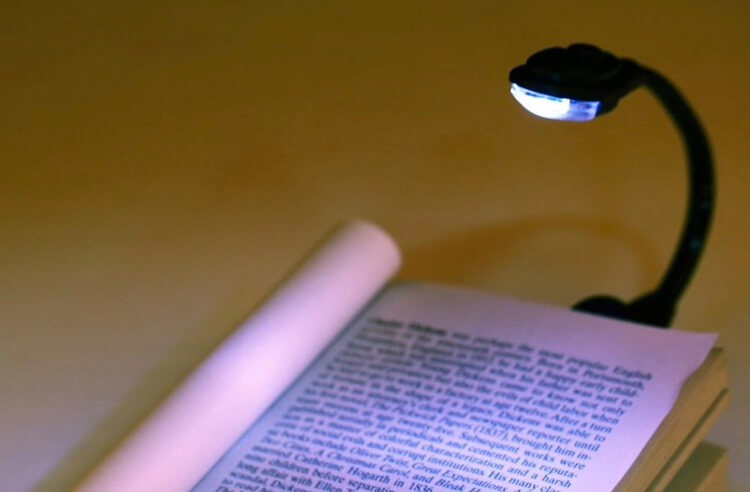 Чтение книг в темноте. Лампа для чтения. Фото.