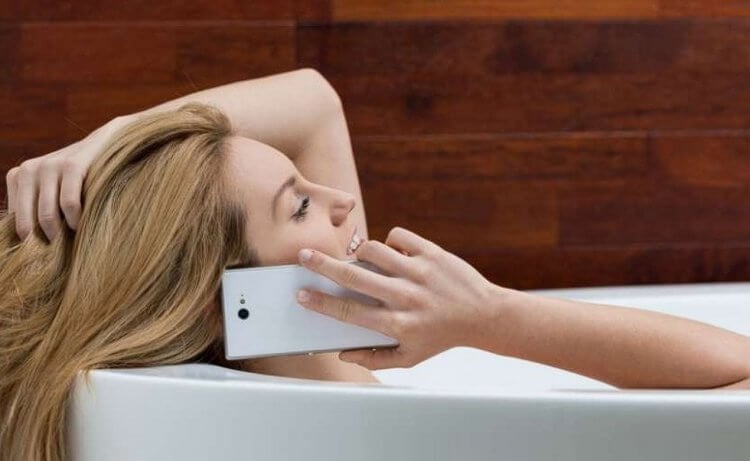 Что будет, если смартфон упадет в ванну с человеком. Смартфоном можно относительно безопасно пользоваться в ванной. Фото.