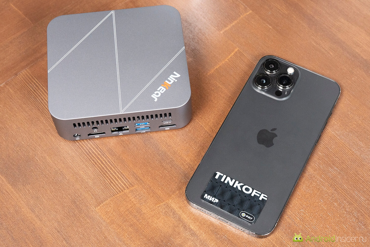 Маленький компьютер на работе. Корпус очень небольшой. Сравнение с iPhone 13 Pro Max. Маленький компьютер на работе. Корпус очень небольшой. Сравнение с iPhone 13 Pro Max. Фото.