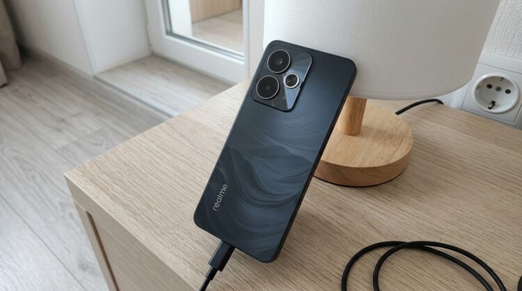 Смартфон Realme на подставке лампы с кабелем зарядки