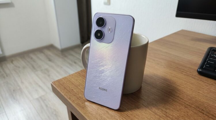 Смартфон Redmi в сиреневом корпусе на столе