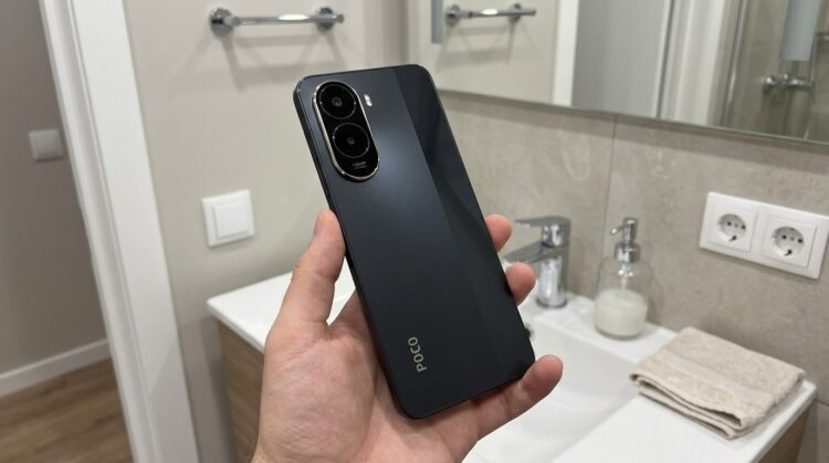 Смартфон Poco C81 Pro в руке, вид сзади