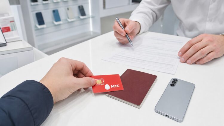 Посетитель отдаёт SIM-карту и паспорт сотруднику МТС